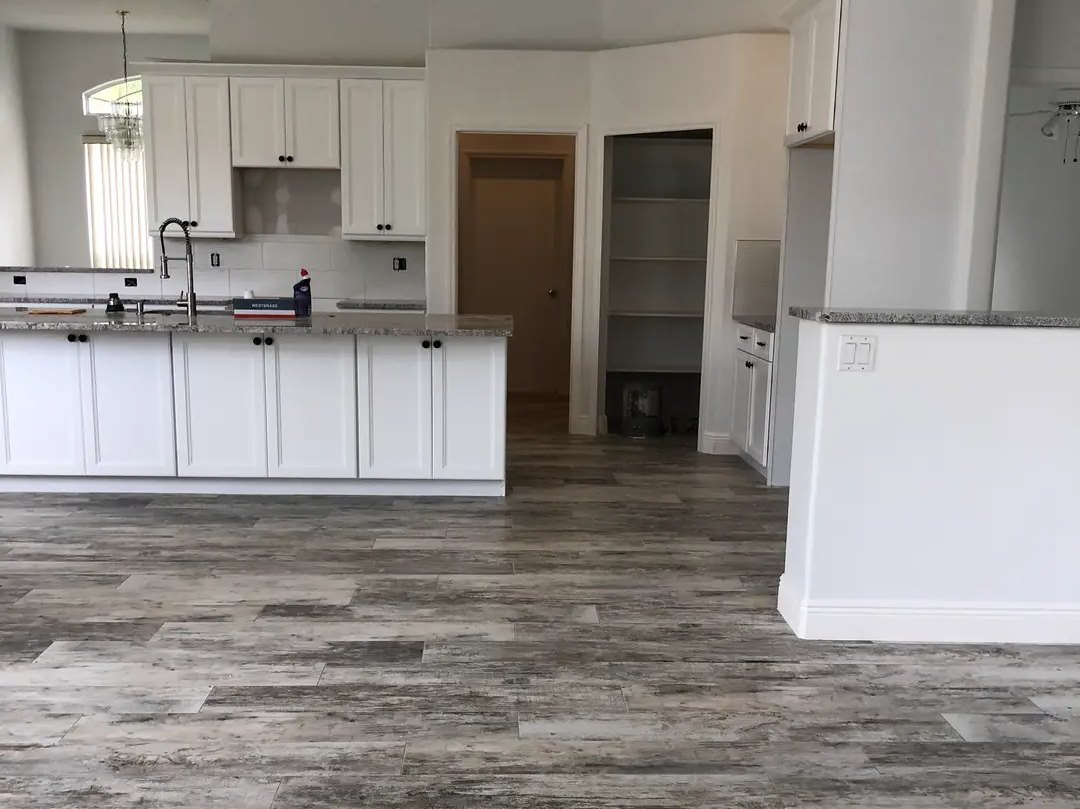 One plank-look tile floor running through the kitchen and living area